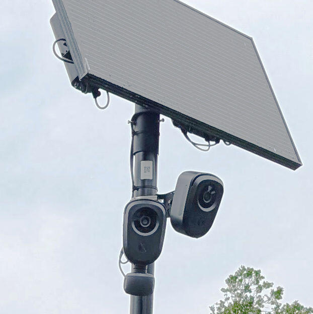 Two Flock cameras mounted on a pole beneat a solar panel.