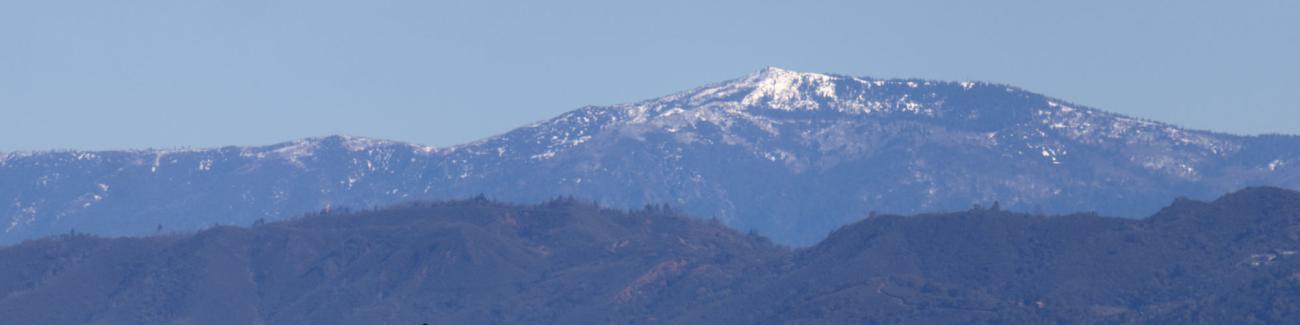 Hills and mountain with a snow cap.